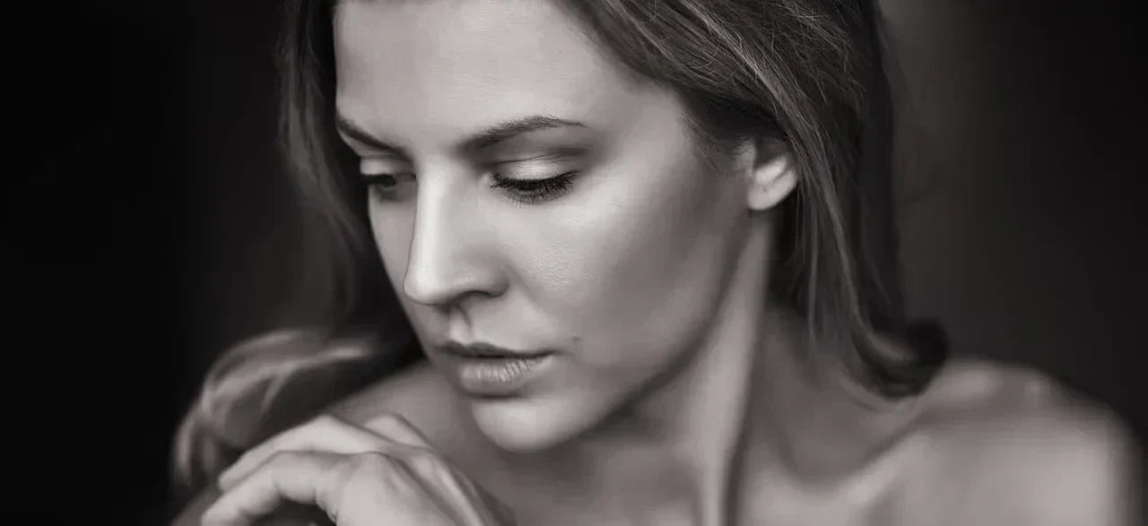 Mujer de pelo largo y tez suave mira a un lado