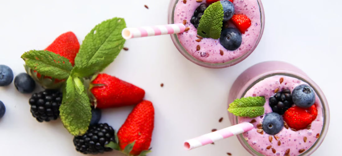 Batido saludable en vasos de pajita decorados con fruta.