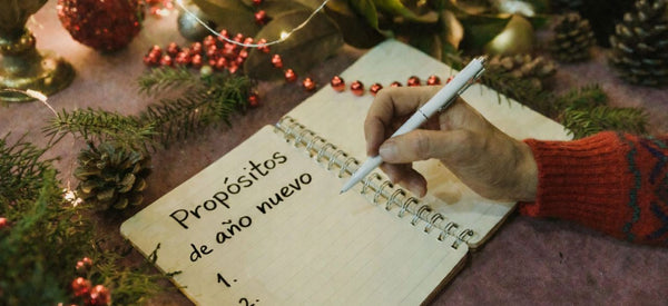 El hombre escribe sus propósitos de Año Nuevo en un cuaderno.