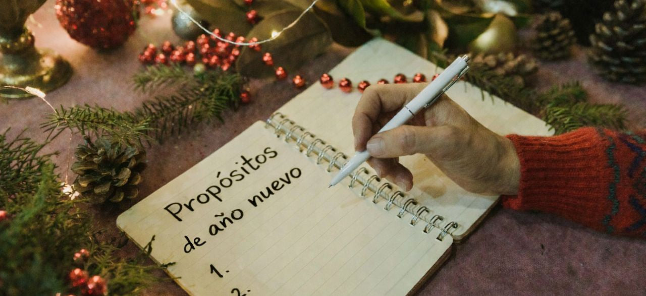 El hombre escribe sus propósitos de Año Nuevo en un cuaderno.