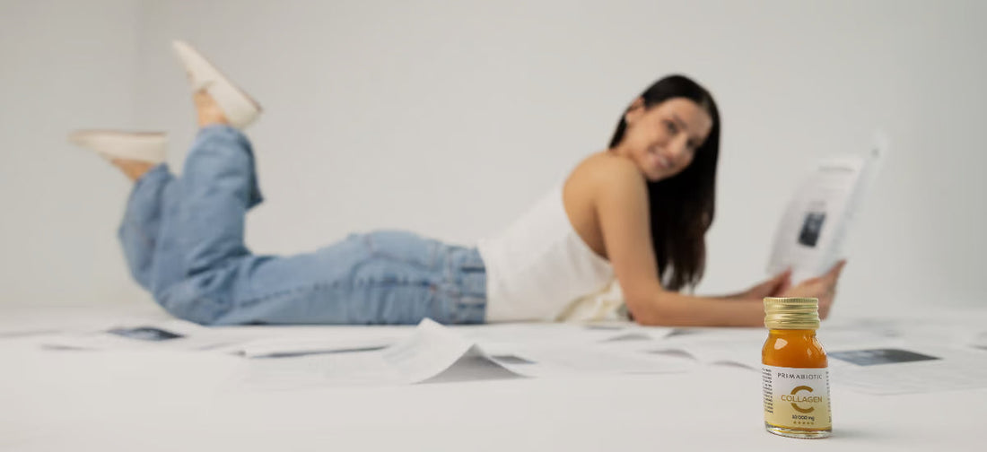 Una mujer sonriente está tumbada leyendo una revista. Delante de ella hay una botella con la nueva fórmula de colágeno Primabiotic.