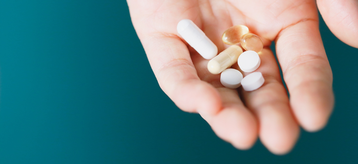 Suplementos dietéticos en comprimidos colocados en la palma de la mano