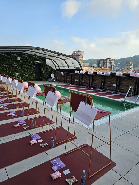 Equipo de entrenamiento de barre dispuesto junto a la piscina, con bolsas de colágeno Primabiotic colgadas en las sillas